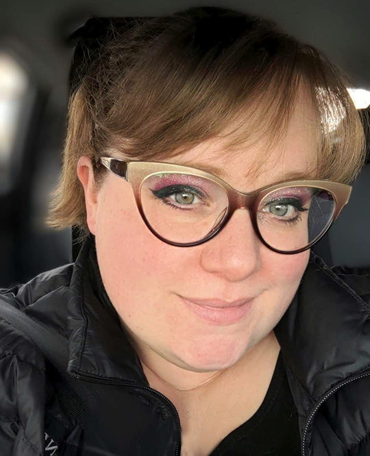 Woman with dark blond hair and glasses