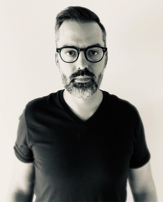 Man with short dark hair, glasses, and facial hair