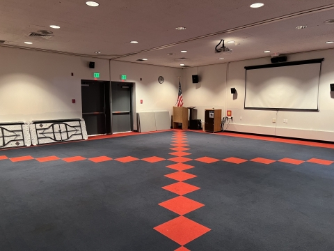 Photo of the large meeting room in open configuration with tables along the wall