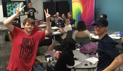 teens playing dungeons and dragons and waving at the camera