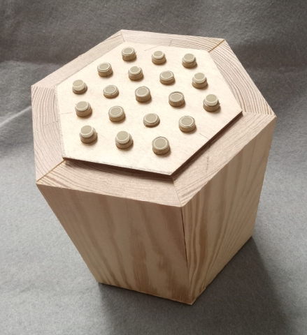 Wooden bee house shown from above showing the tubes where bees go in.