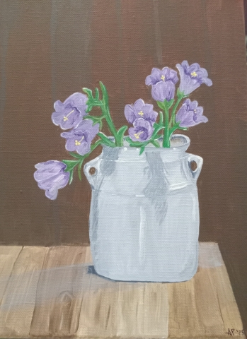 Painting of purple flowers in a grey container on a wooden table against a brown paneled wall. 