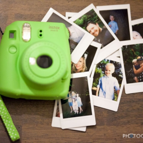 mini green polaroid camera with assorted pictues of people