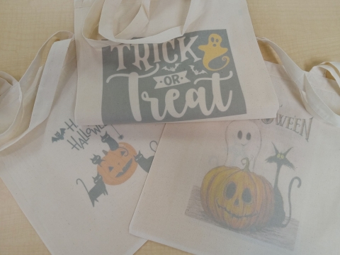 Three bags with images - one with a cat, pumpkin adn ghost, one with "Trick or Treat" with a yellow ghost and one with a pumpkin with black cats.