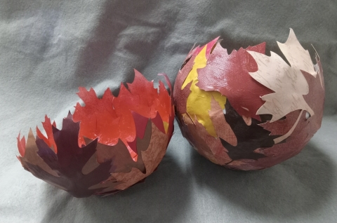 Two bowls made from paper leaves in various shades of brown, tan, yellow and red.