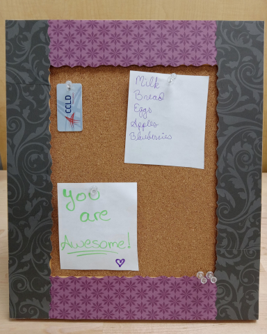 Black and purple framed cork board