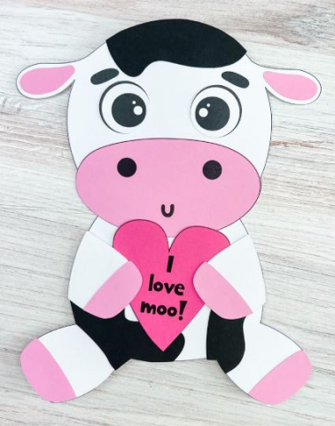 Cow made from paper holding a heart that says I love moo.