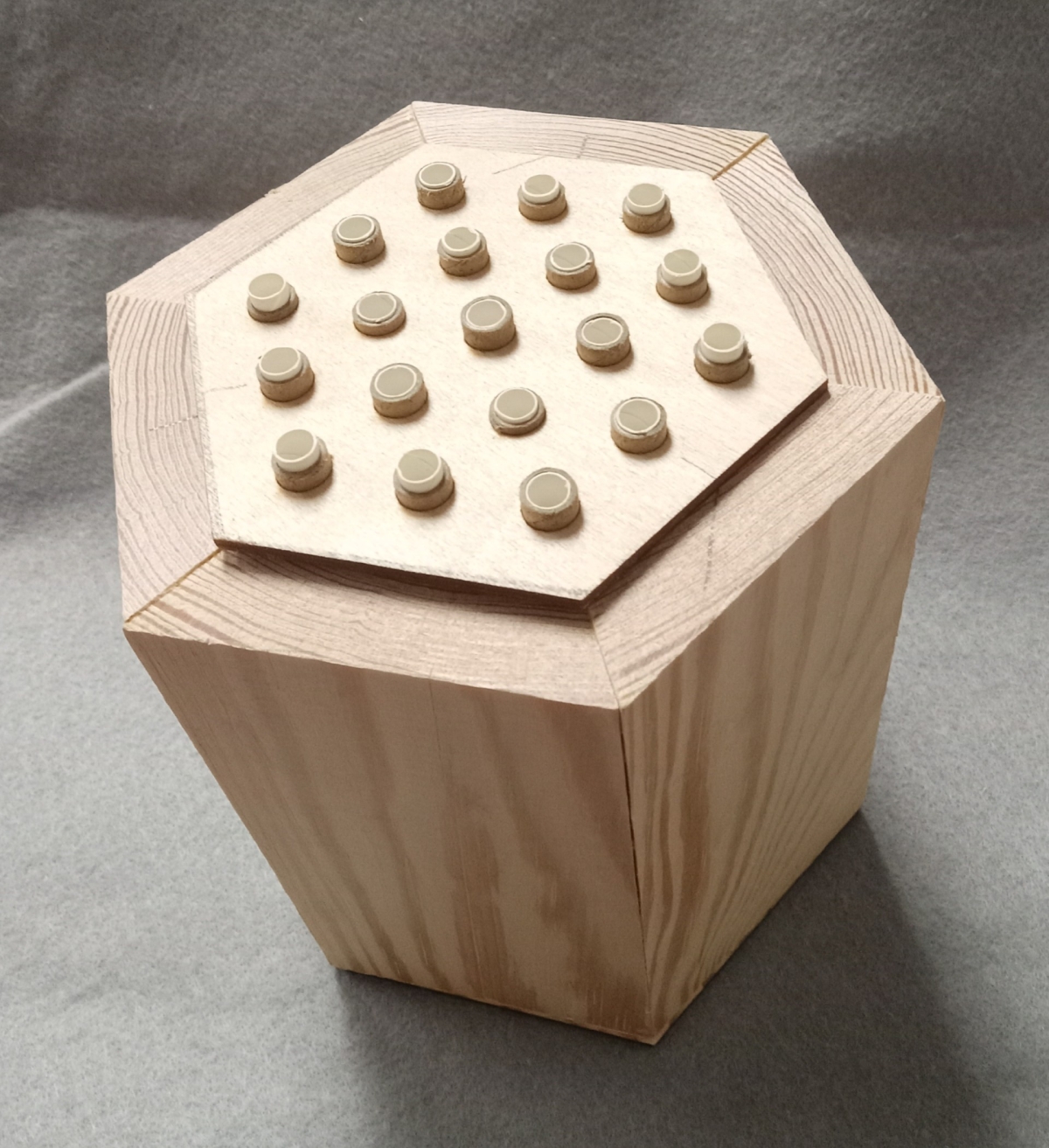 Wooden bee house shown from above showing the tubes where bees go in.
