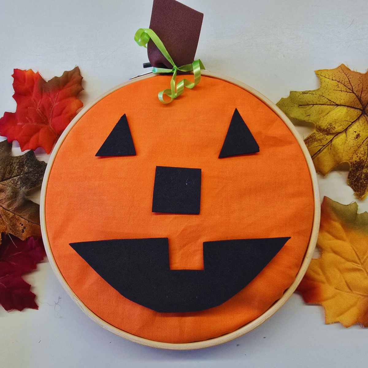 Orange jack-o-lantern made in an embroidary hoop